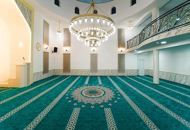 Mosque Carpet Supplier UAE displaying patterned prayer carpets installed in a spacious mosque prayer hall with aligned rows