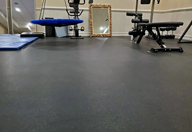 Rubber Gym Flooring with interlocking black tiles installed in a commercial fitness area for weight training use